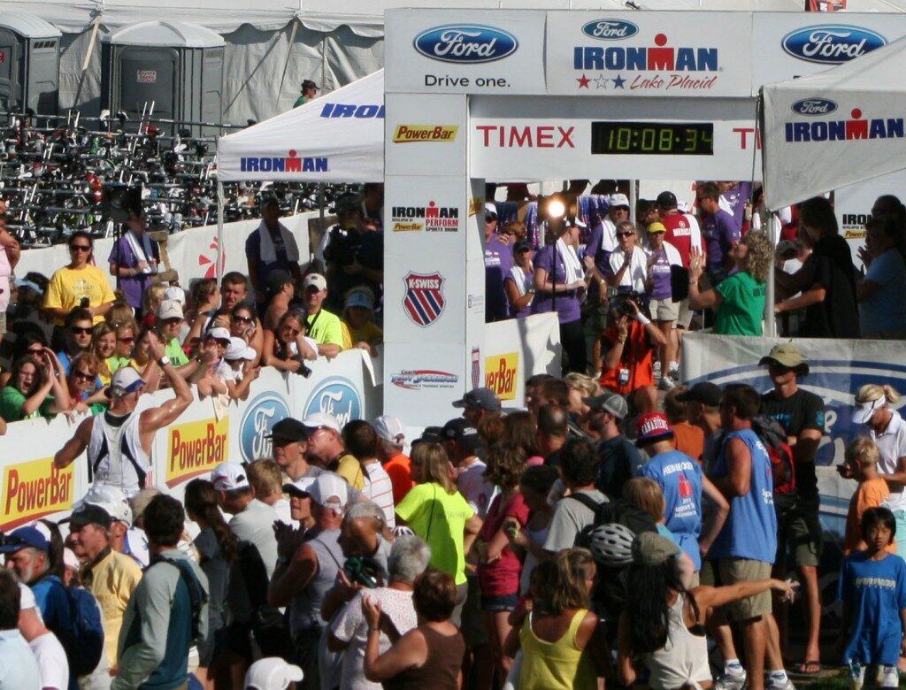 A crowd of people standing in front of a finish line.