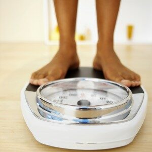 A woman's feet standing on a weight scale.