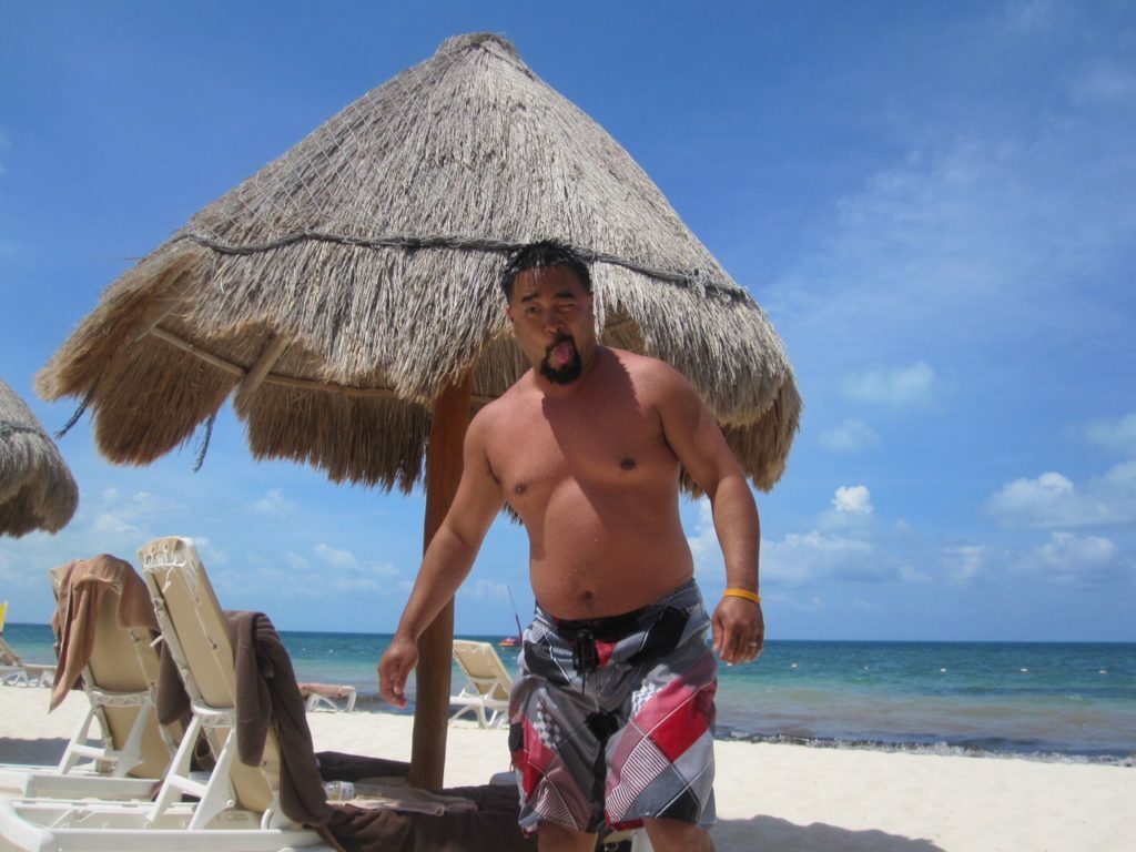 A man in a bikini on the beach.