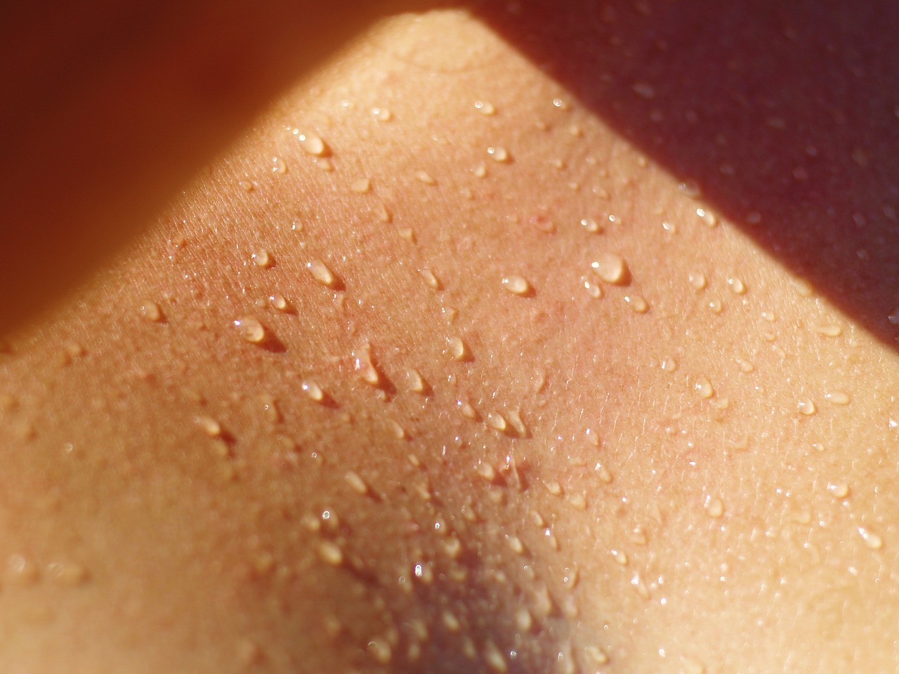 A close up of a person's chest with water droplets on it.