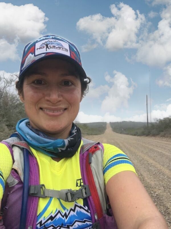 A woman is taking a selfie on a dirt road.