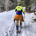 A person is skiing down a snowy trail.