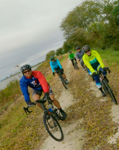 A group of people riding bikes on a dirt road.