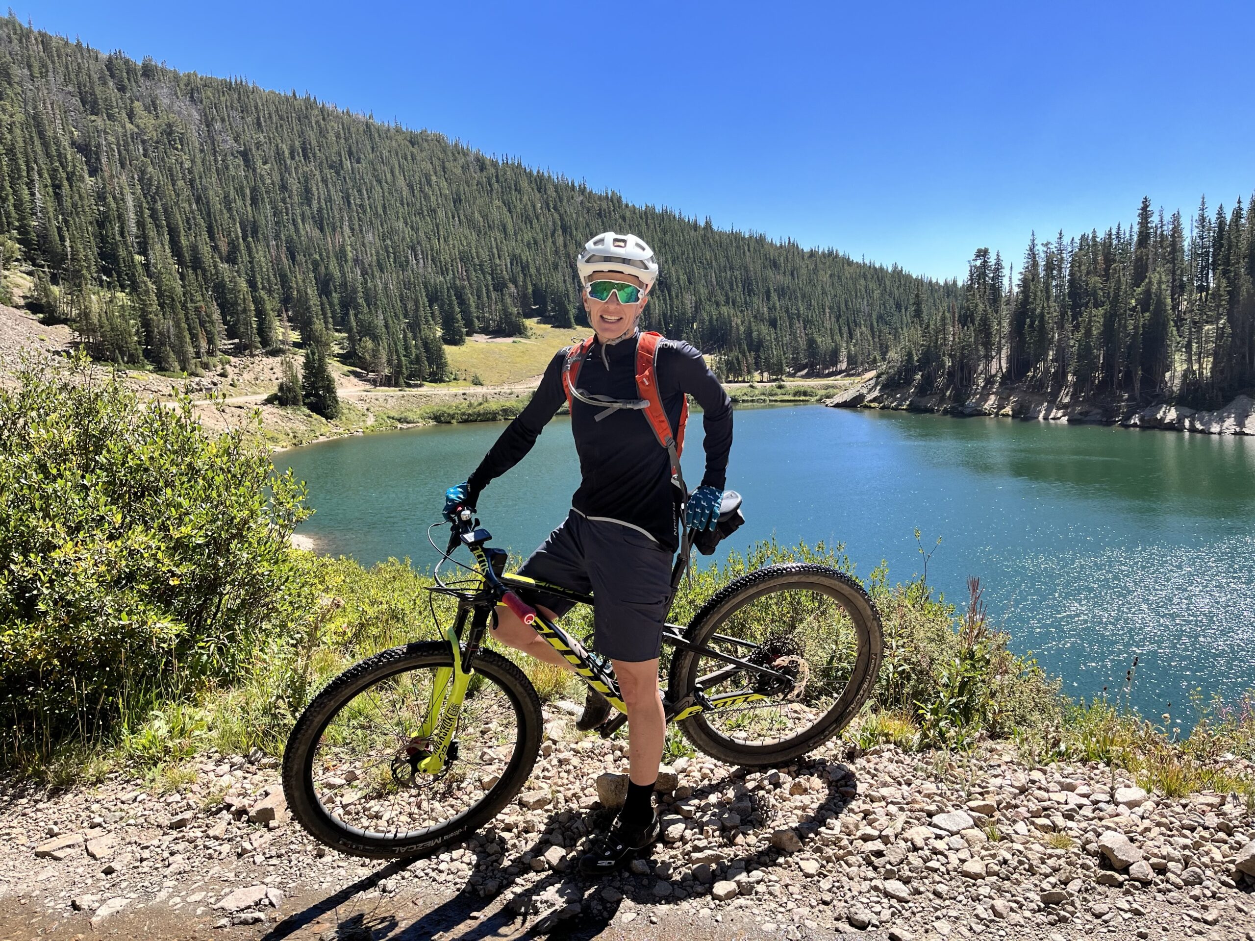 Coach Sophie Evans on mountain bike near a lake